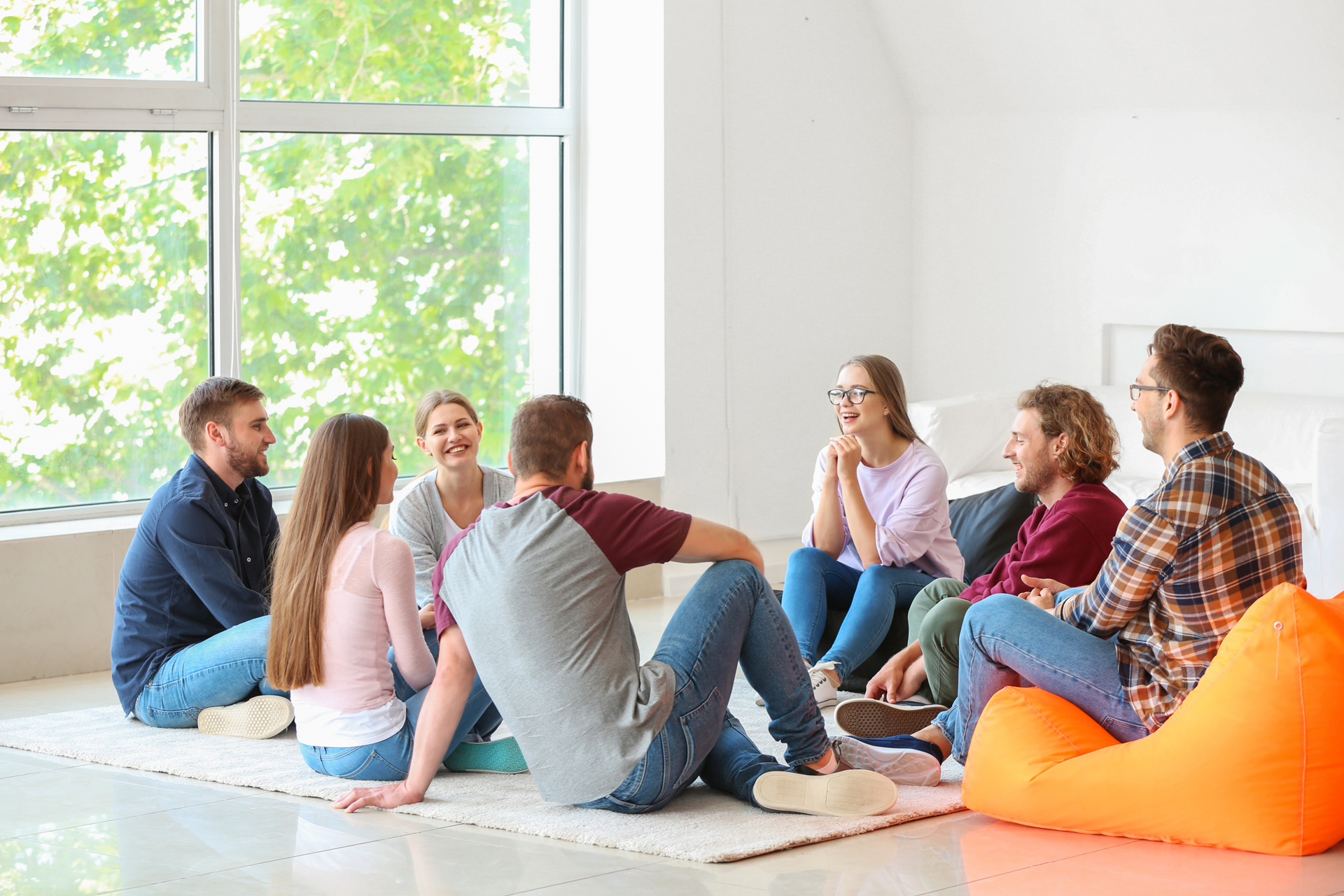 group sitting comfortably on the floor in a relaxed setting for group therapy