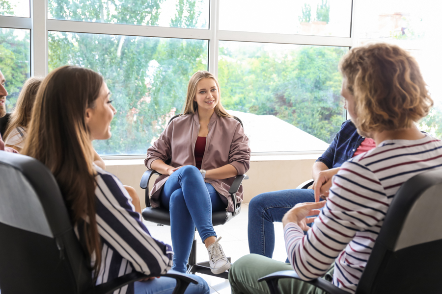 women sitting in a circle on chairs in a group meeting