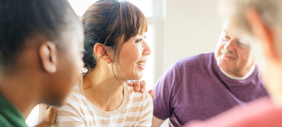 woman smiling in group therapy as she receives support