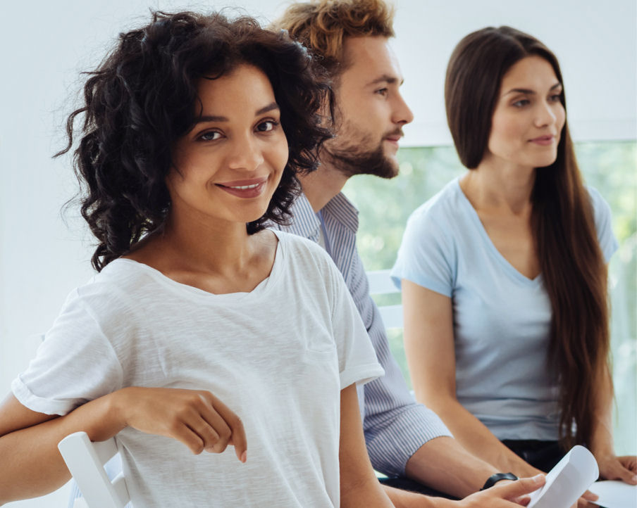 woman turning towards camera during group meeting