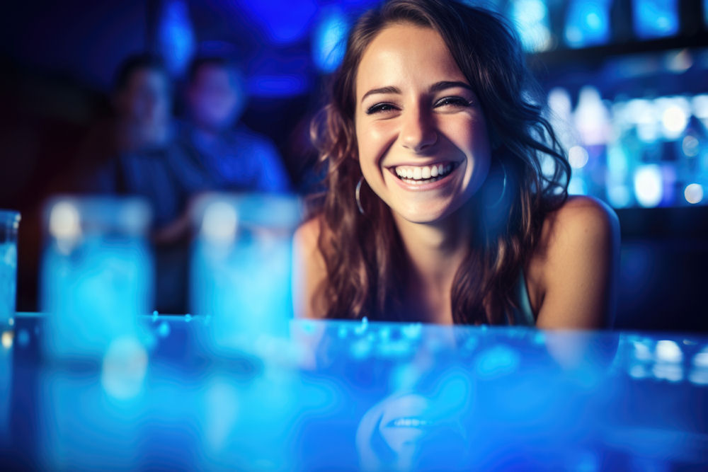 Smiling woman at a club, possibly experiencing effects of party drugs in a vibrant nightlife setting